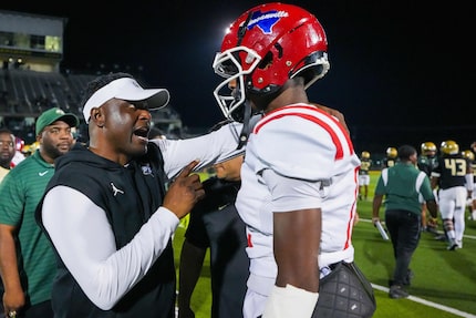 DeSoto head coach Claude Mathis talks with Duncanville quarterback Keelon Russell after...