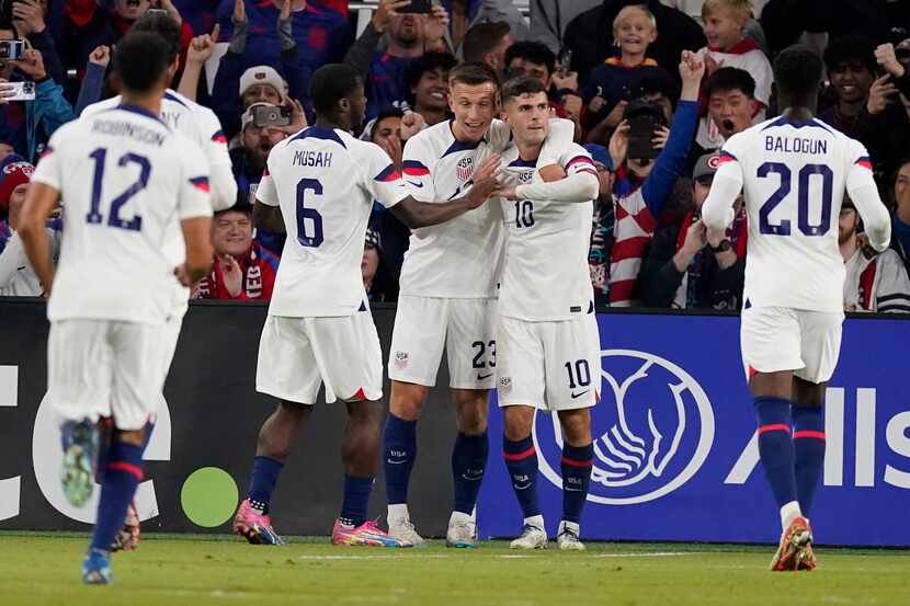 United States teammates congratulate forward Christian Pulisic (10) after a goal against...