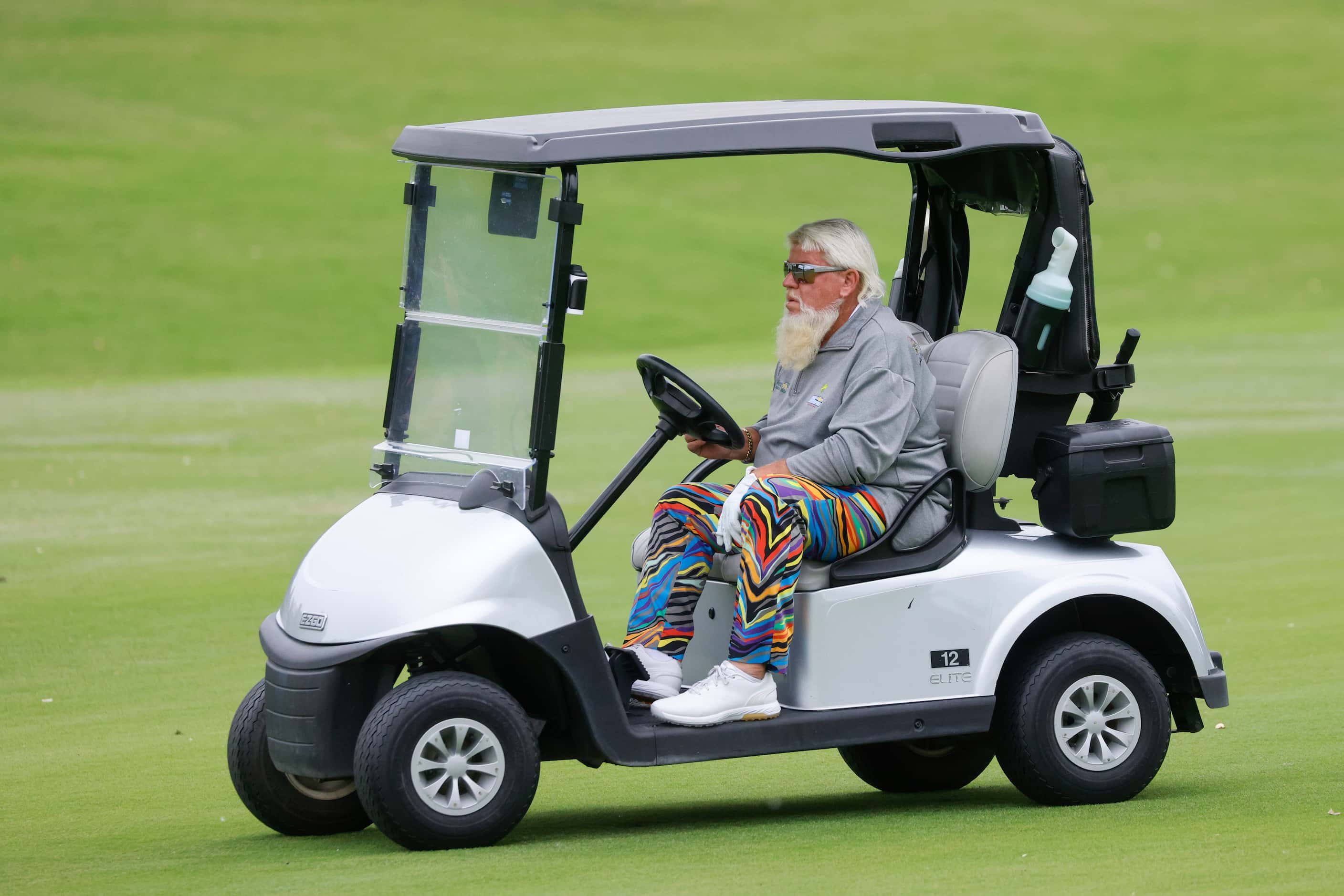 John Daly drives to his ball on the 18th fairway during the first round of the Invited...
