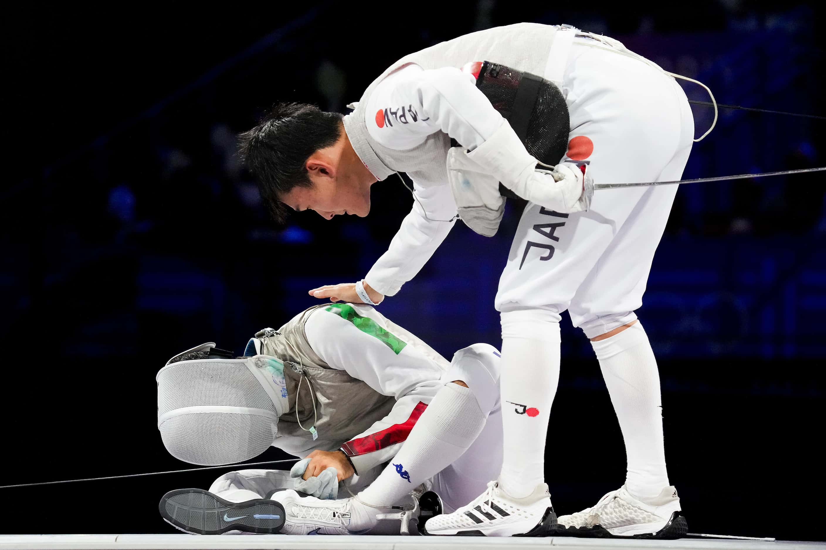 Kyosuke Matsuyama of Japan checks on his opponent Guillaume Bianchi of Italy after he was...