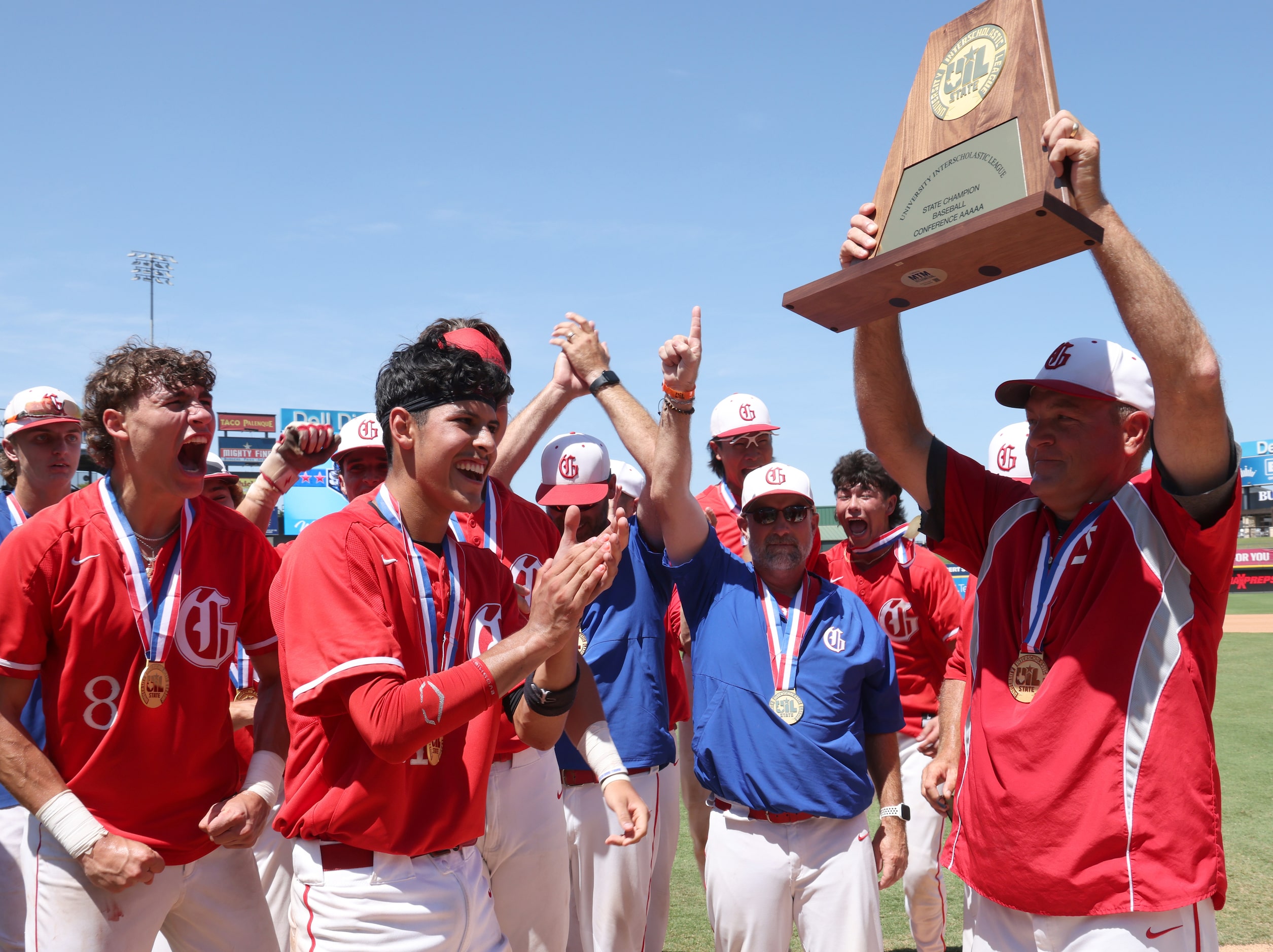 Grapevine head coach Jimmy Webster, right, hoists the Class 5A state championship trophy to...