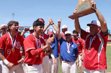 Grapevine head coach Jimmy Webster, right, hoists the Class 5A state championship trophy to...