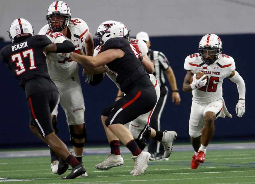 Texas Tech running back Ta'Zhawn Henry (26) explores a running lane provided by offensive...