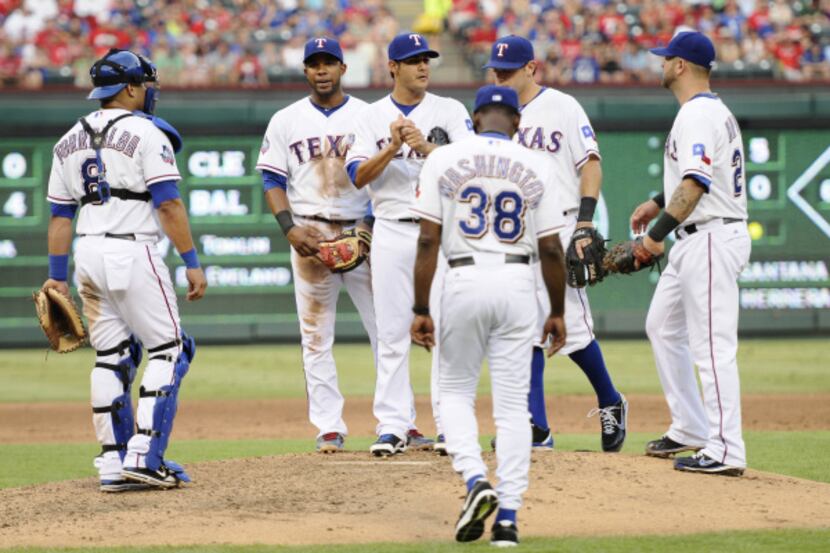 Texas Rangers starting pitcher Martin Perez, center, is relieved by manager Ron Washington...