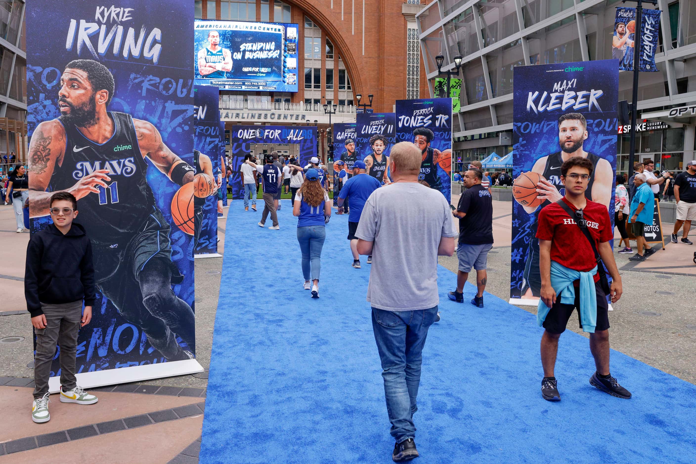 Dallas Mavericks fans pose for pictures on a blue carpet outside American Airlines Center...