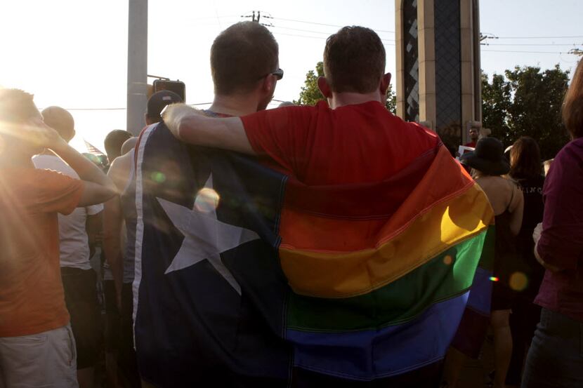 Jacob Gerber, left and Brandon Kirk wrapped their "Texas Pride" flag around them at the...