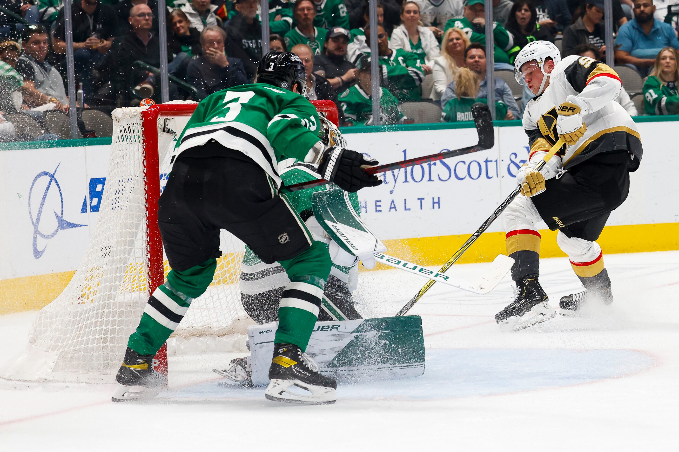 Dallas Stars goaltender Jake Oettinger (29) stops a puck from Vegas Golden Knights center...