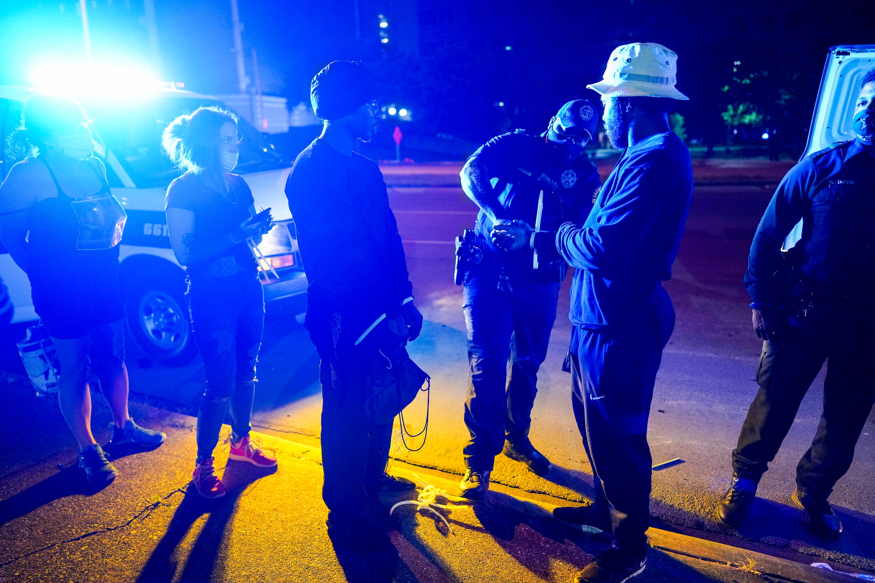 Protesters have their disposable cuffs removed as they are released outside the Frank...