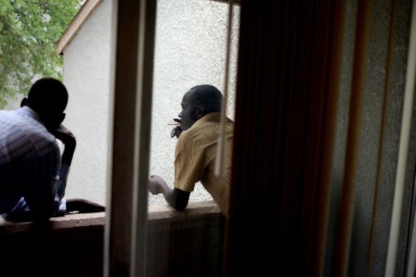 Mohammed Adam (right) relaxed on his apartment balcony with friend Hassan Ismael, a refugee...