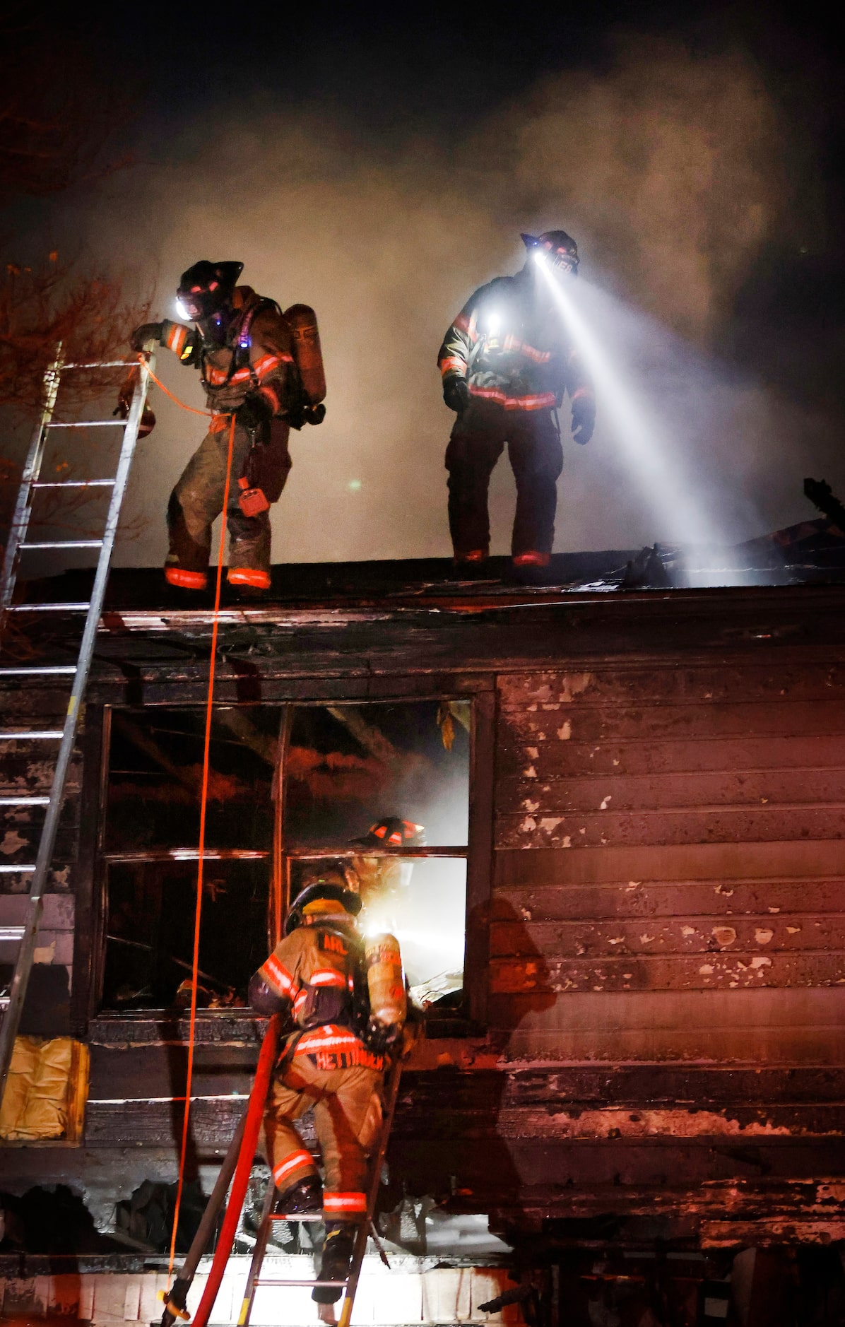 Arlington firefighters put out hot spots on the second floor and roof as they battle a...