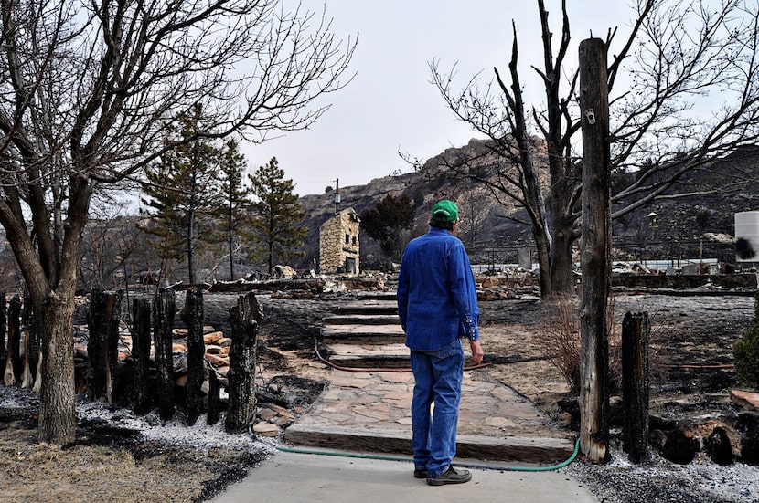 John Erickson, author of the Hank the Cowdog books, looks at his destroyed home after a...