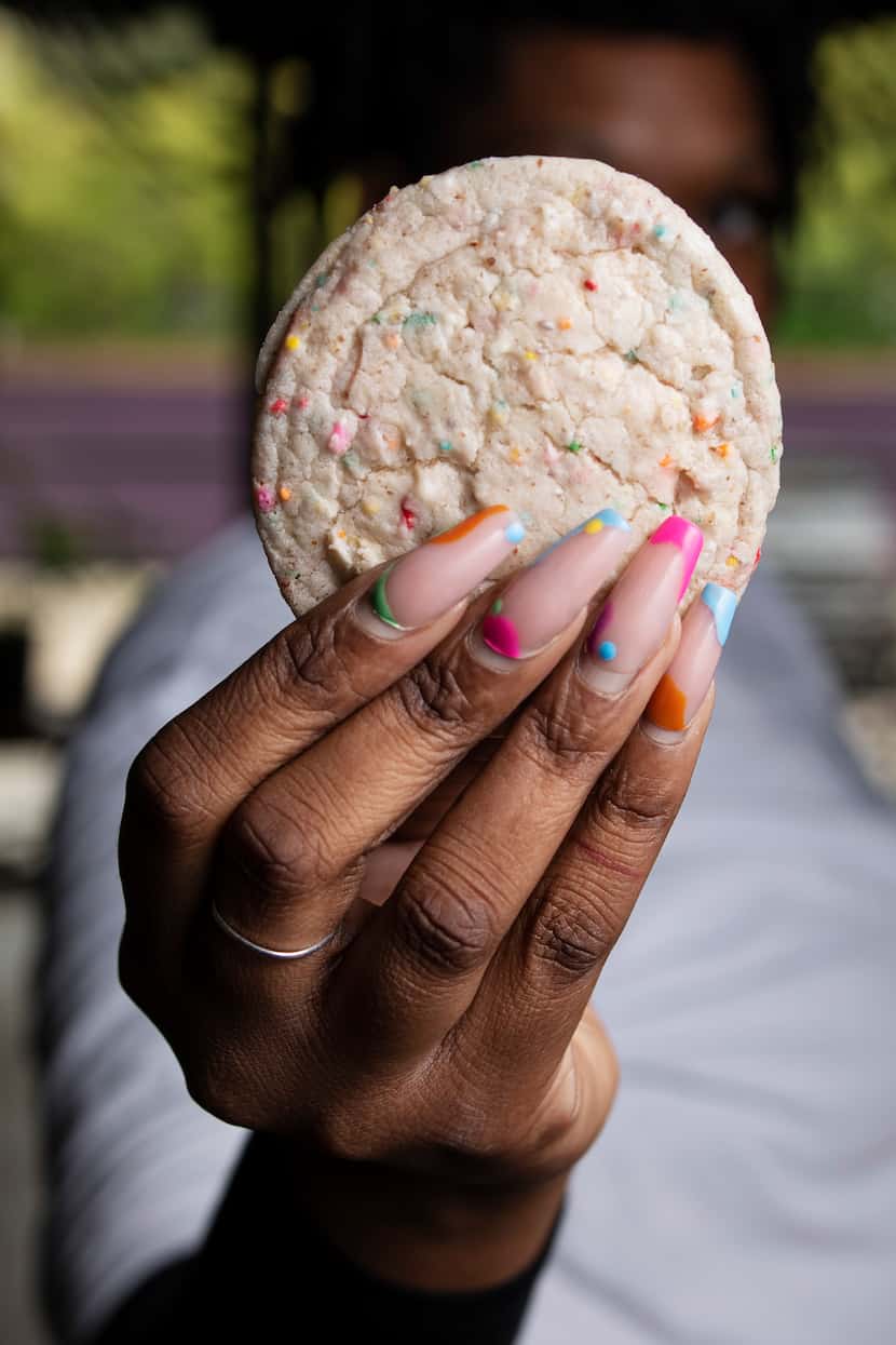 Rachel Harvey, also known as DJ Ursa Minor, holds one of the vegan confetti cookies she...