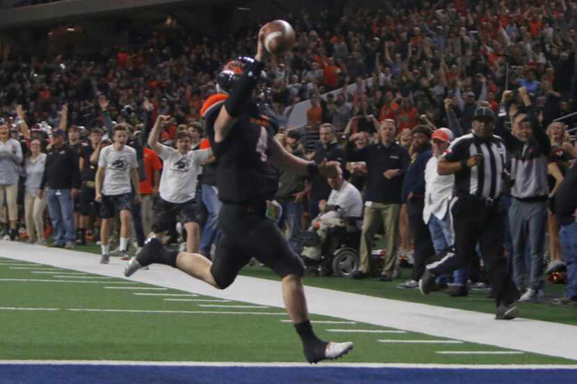 Aledo quarterback Jake Bishop (4) raises the ball over his head and ignites Bearcats fans as...