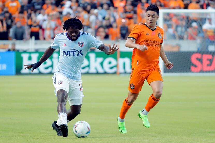 FC Dallas midfielder Ema Twumasi, left, moves the ball in front of Houston Dynamo midfielder...