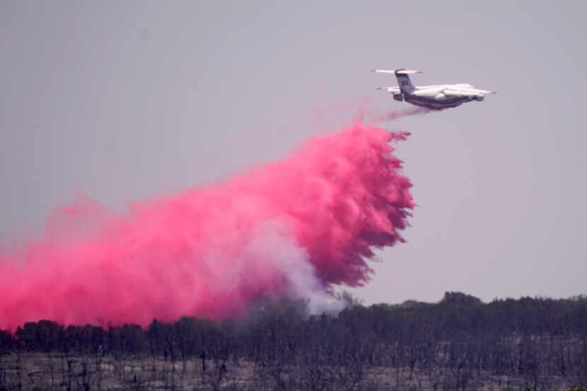 An airplane drops fire retardant on a wildfire near Glen Rose on Wednesday. 