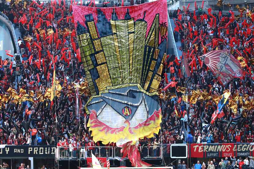 Atlanta United fans hoist a tifo to support their team to begin an MLS soccer match against...