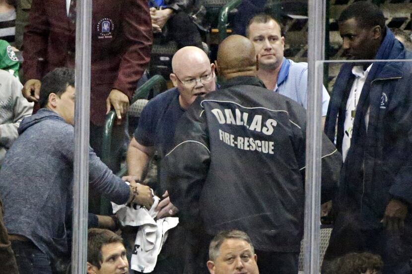 Dallas Fire Rescue personnel  attend to a man who was hit by a puck during the second period...