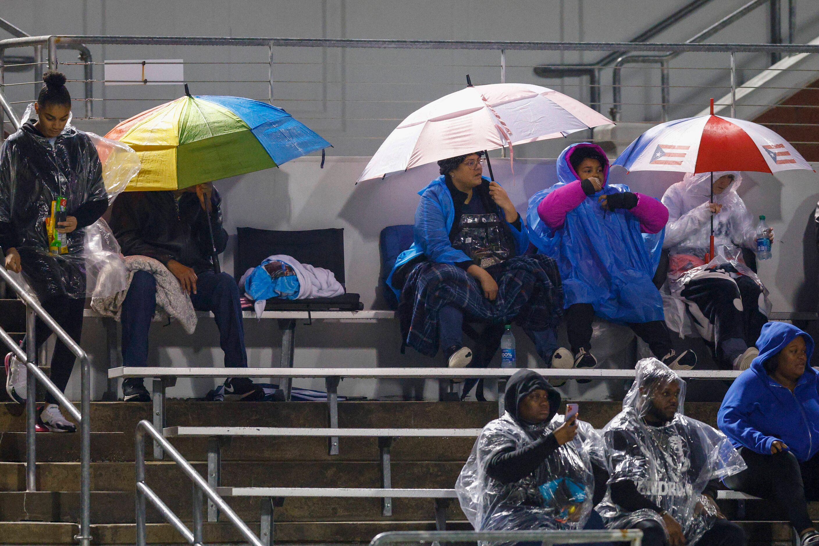 Mansfield Timberview fans shelter from the rain underneath umbrellas during the first half...