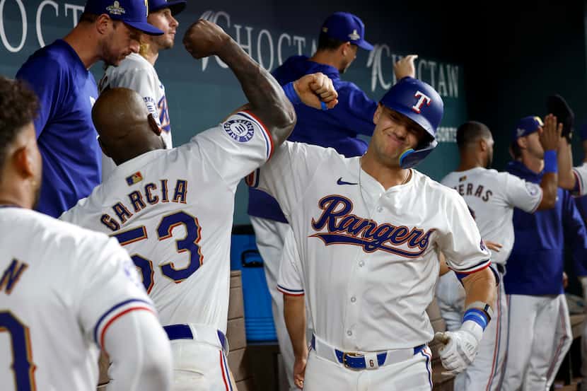 Texas Rangers third baseman Josh Jung (6) celebrates his two-run home run in the dugout with...