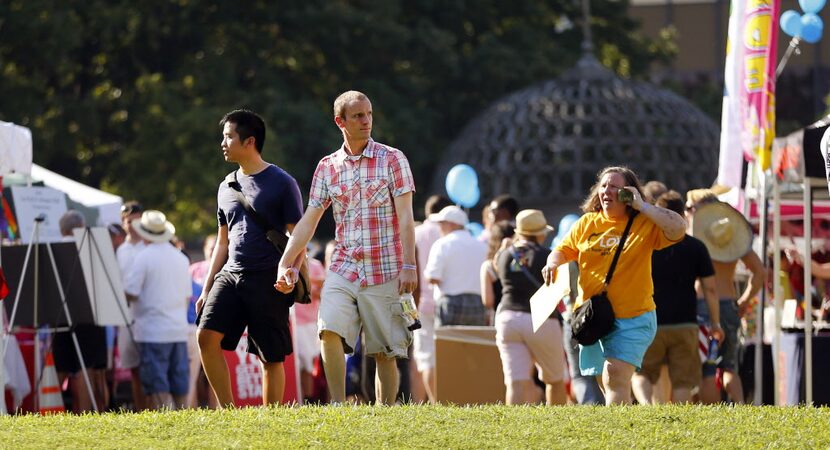 A couple walks among the festival booths in Lee Park following the Alan Ross Texas Freedom...