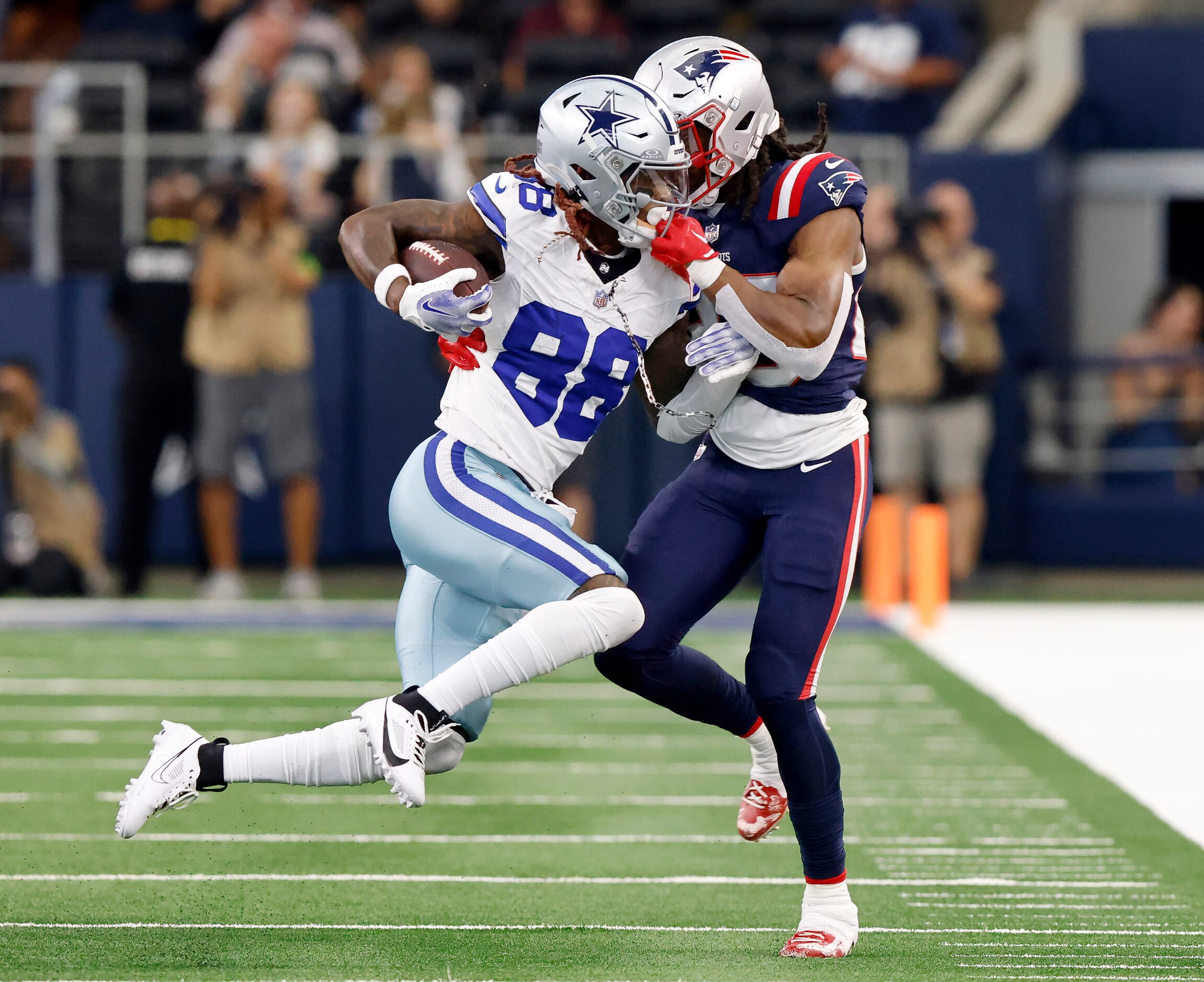 Dallas Cowboys wide receiver CeeDee Lamb (88) is face masked by New England Patriots safety...