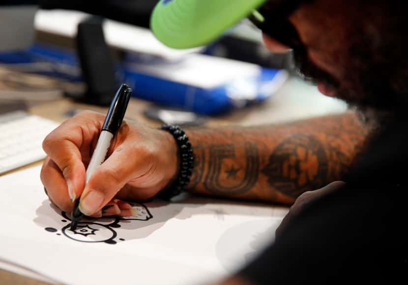 Tex Moton uses a Sharpie to create a new design.