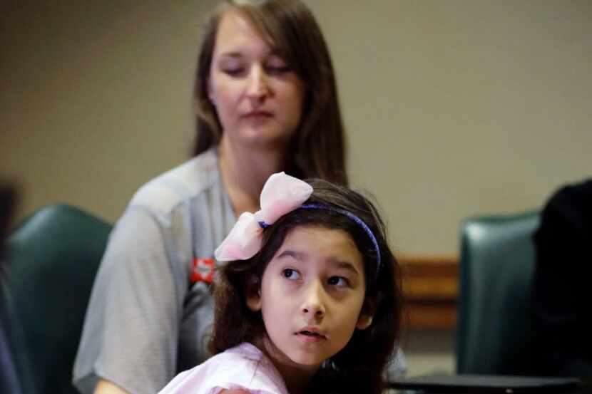 Libby Gonzales, a transgender girl, sits with her mother Rachel during a news conference...