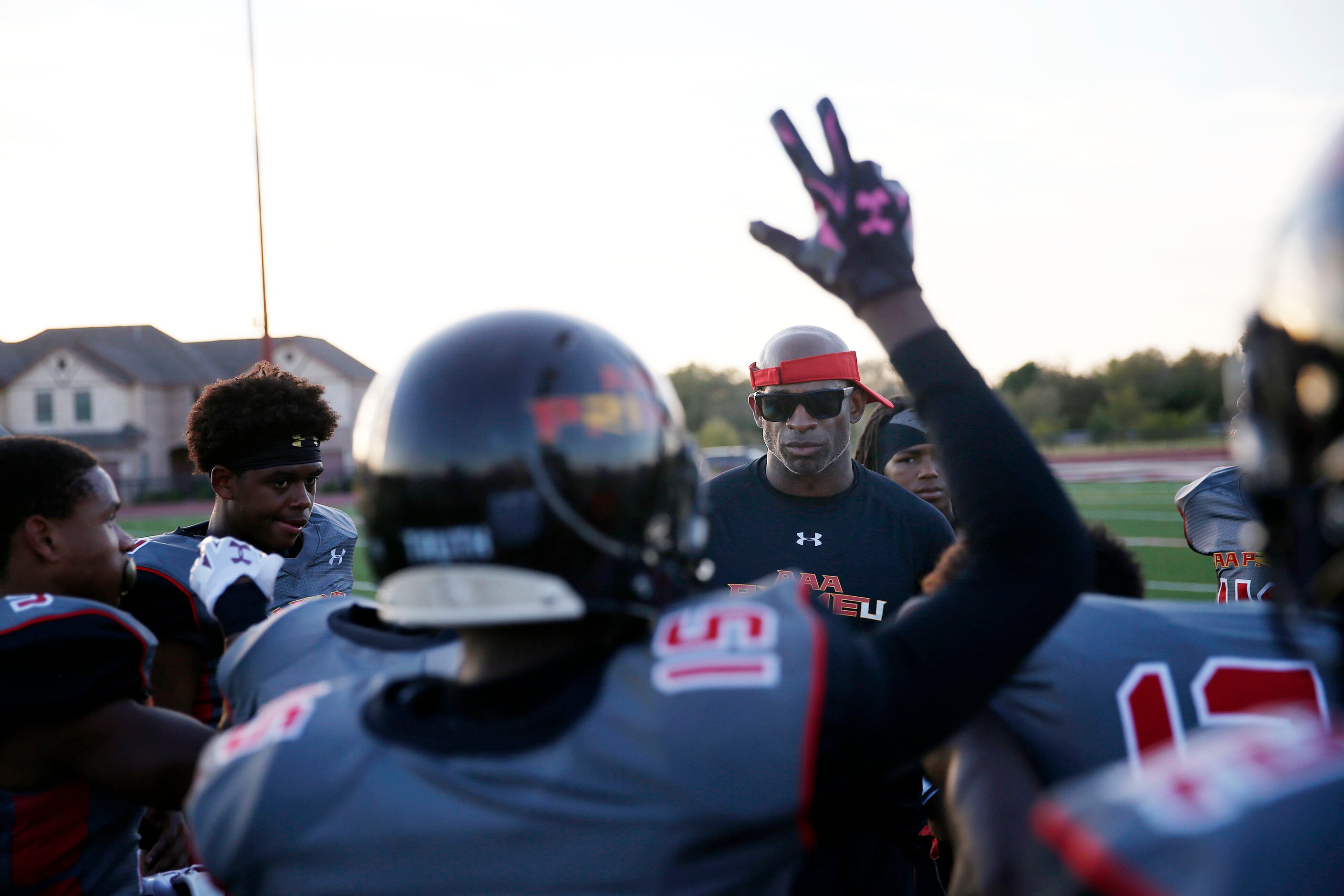 AAA Prime U coach Deion Sanders speaks to his players before a high school football game...