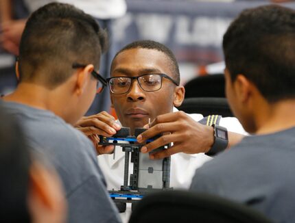 West Point Cadet Lt. James Grays helps Mauricio Pantoja, 12, left, and Christian Orozco, 15,...