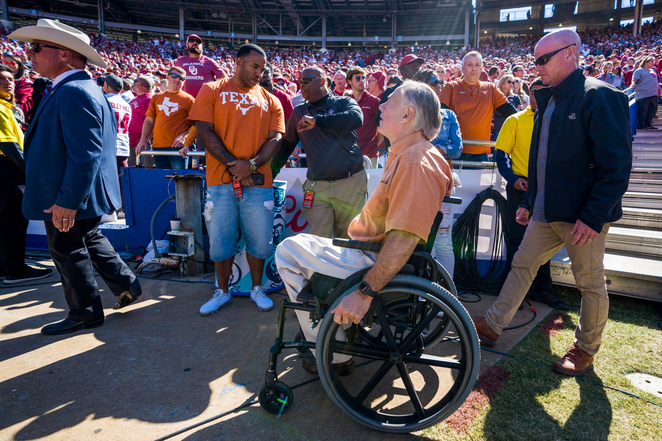 Texas Gov. Greg Abbott leave the field during the second half of an NCAA football game...