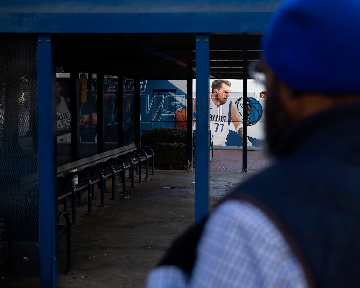 Randy Thornton looked back at a Dallas Mavericks mural on a passing bus while waiting for...