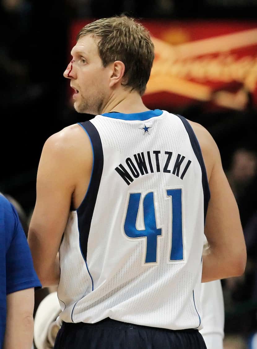Dallas Mavericks forward Dirk Nowitzki (41) heads to the bench to receive medical attention...