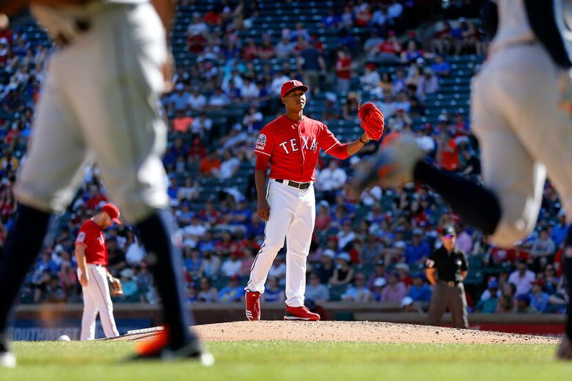 Texas Rangers relief pitcher Jose Leclerc watches Houston Astros batter George Springer...