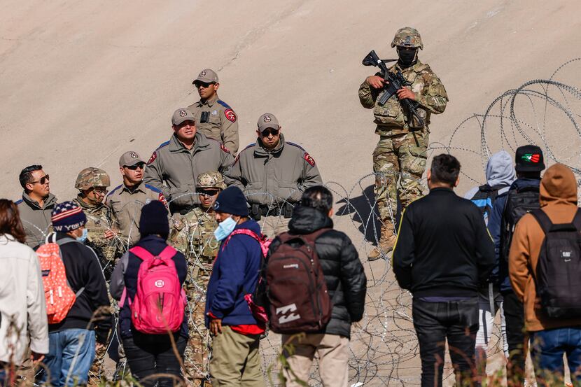 Migrants start to gather close to where the end of Texas National Guards are deployed at...