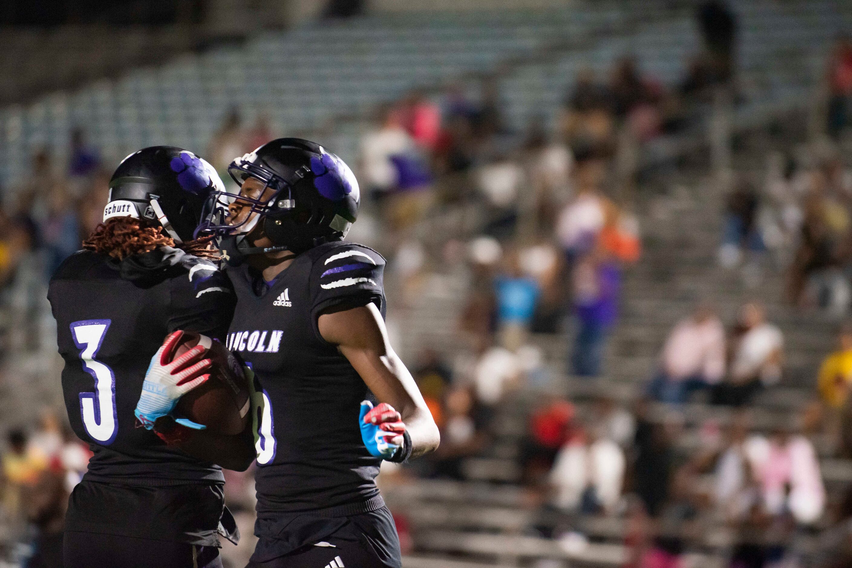 From left, Lincoln senior Martavion Bull (3) congratulates Lincoln senior Jamel Hardy (6)...