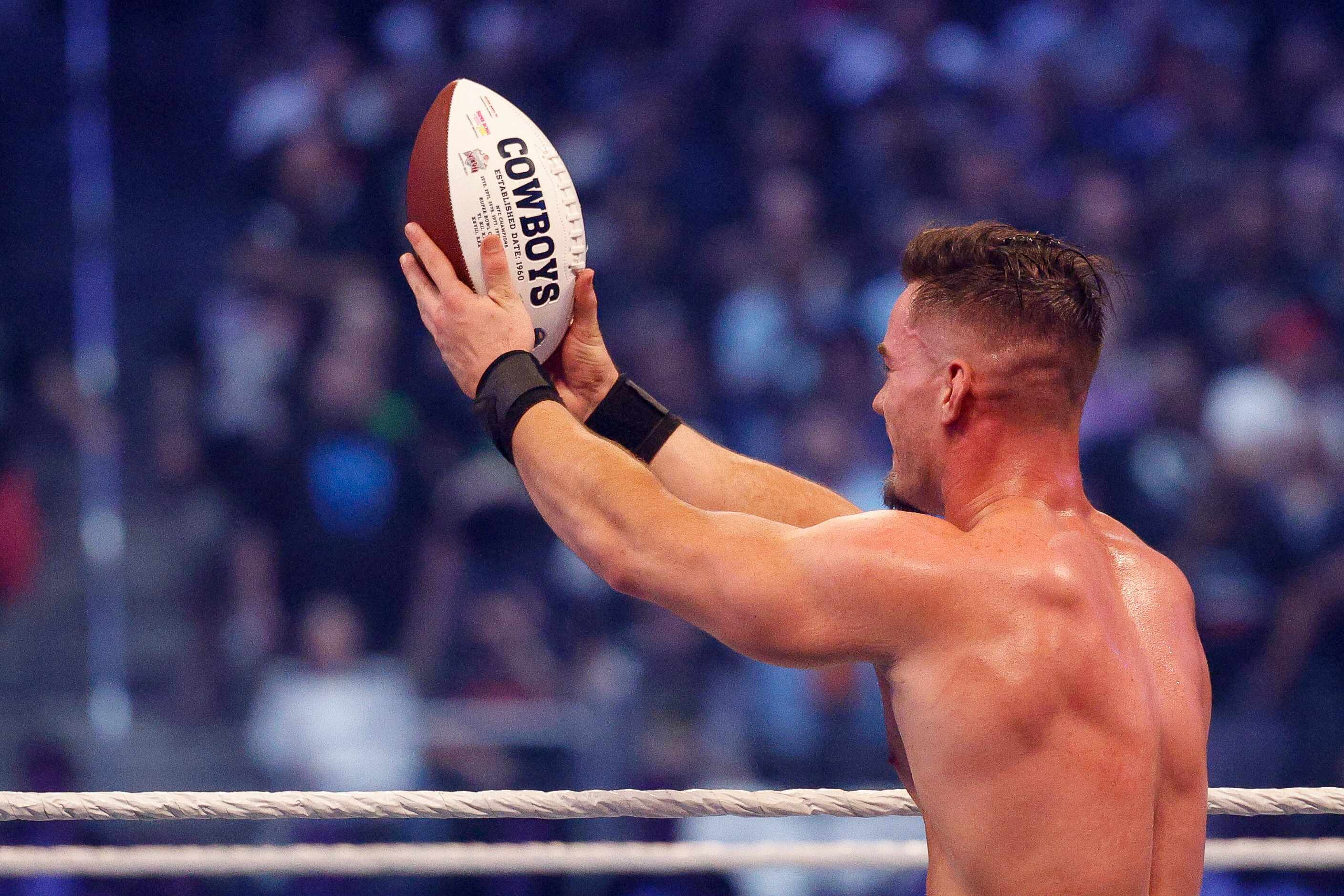 Austin Theory carries a Dallas Cowboys football during a match at WrestleMania Sunday at...
