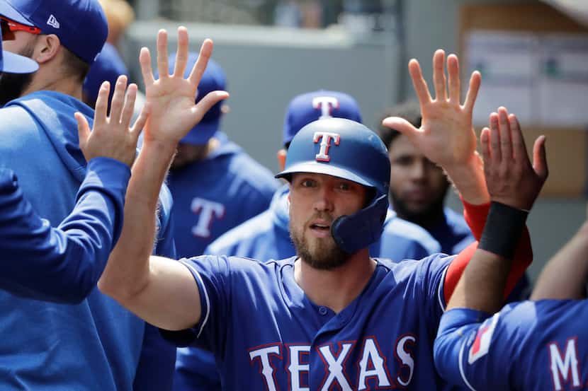 Texas Rangers' Hunter Pence is greeted in the dugout after he scored on an RBI single hit by...