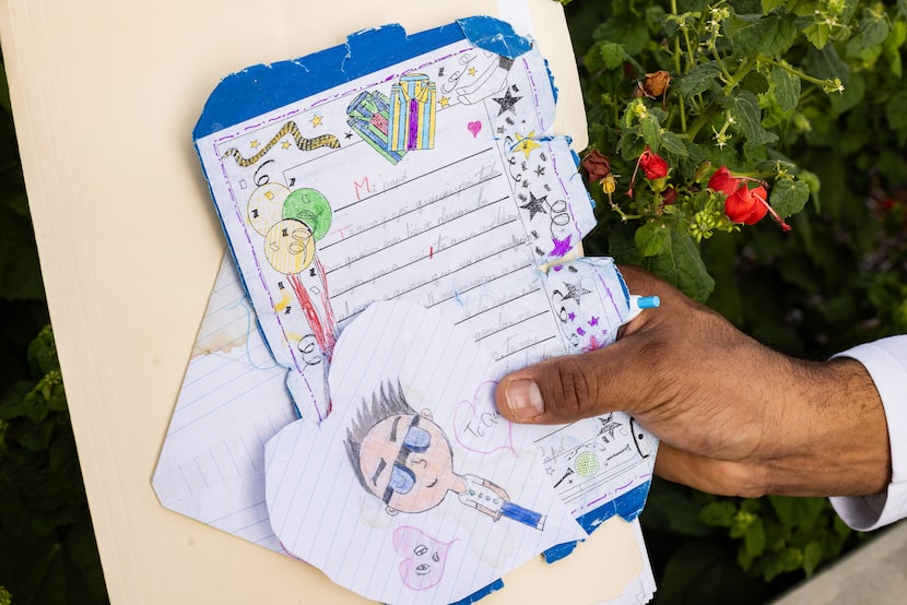 Beckenbauer Franco, 42, from Venezuela, holds letters and drawings from his daughter as...