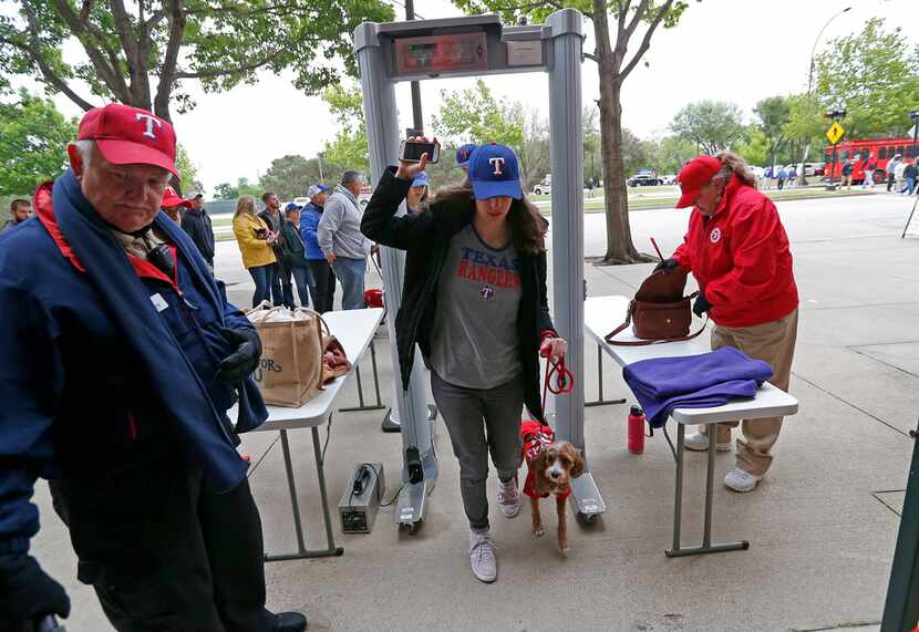Rangers fan Karis Cendall goes through a metal detector with her dog Ranger during the...