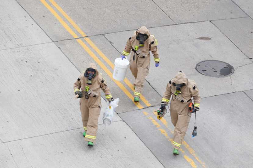 Officers remove a suspicious package that was found near the north entrance of Jack Evans...