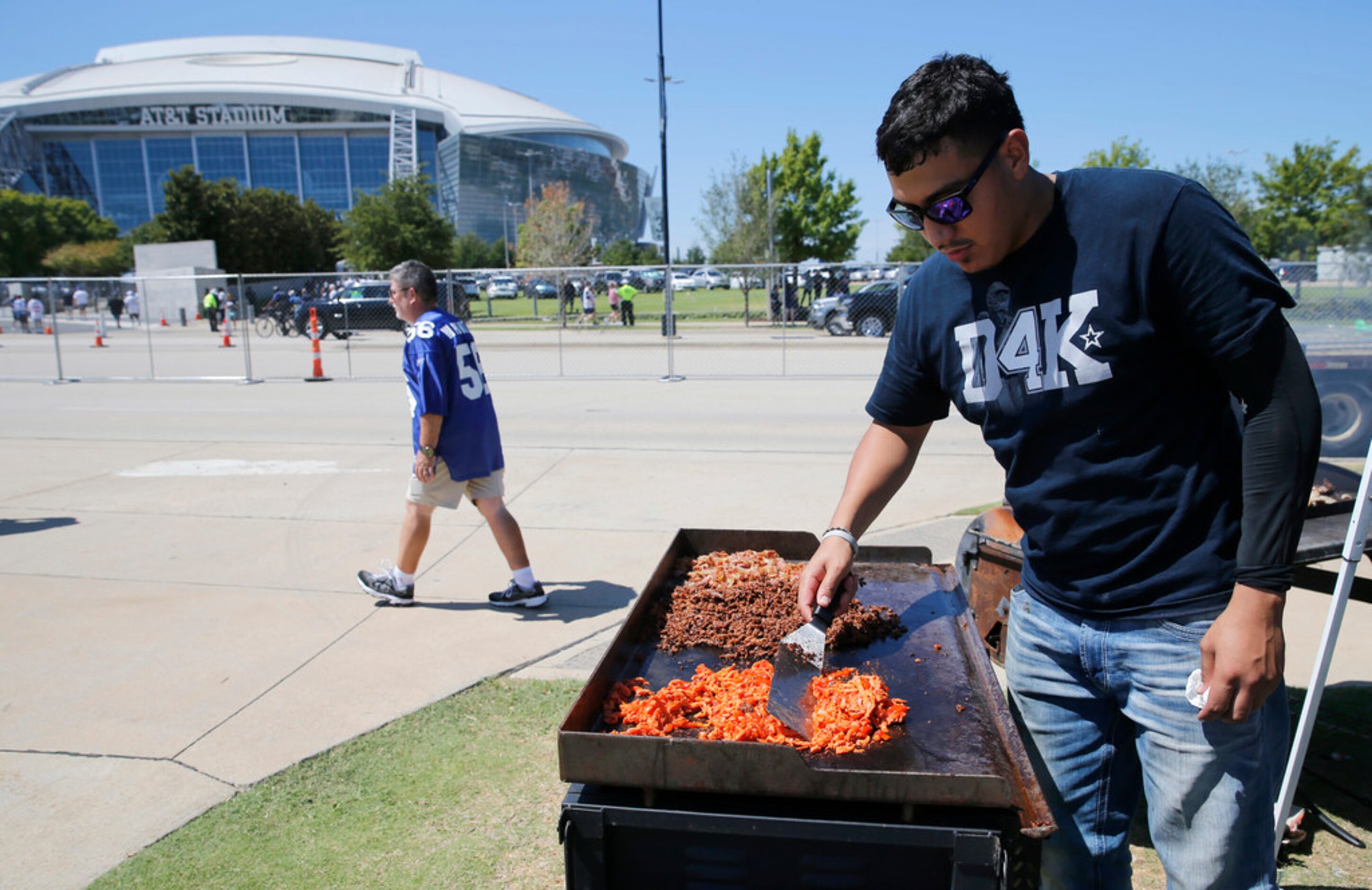 Francisco Correa of Dallas works the grill before the home opener between the Dallas Cowboys...