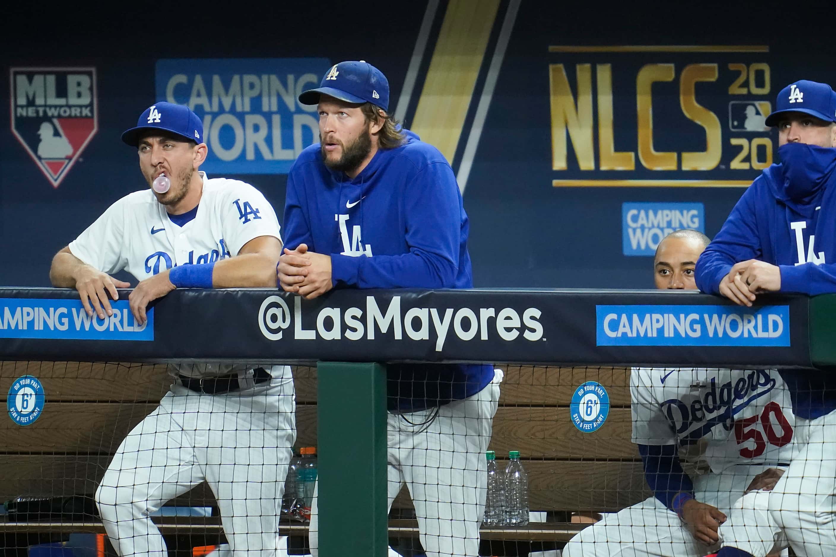 Los Angeles Dodgers starting pitcher Clayton Kershaw (center) watches from the dugout with...