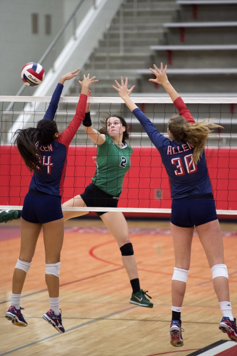 Allen junior outside hitter Lauren Moussaid (24) and junior middle blocker Natalie Fry (30)...