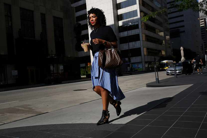 Dominique Wade,  an assistant buyer at Neiman Marcus, walks along Commerce Street on  July 7. 