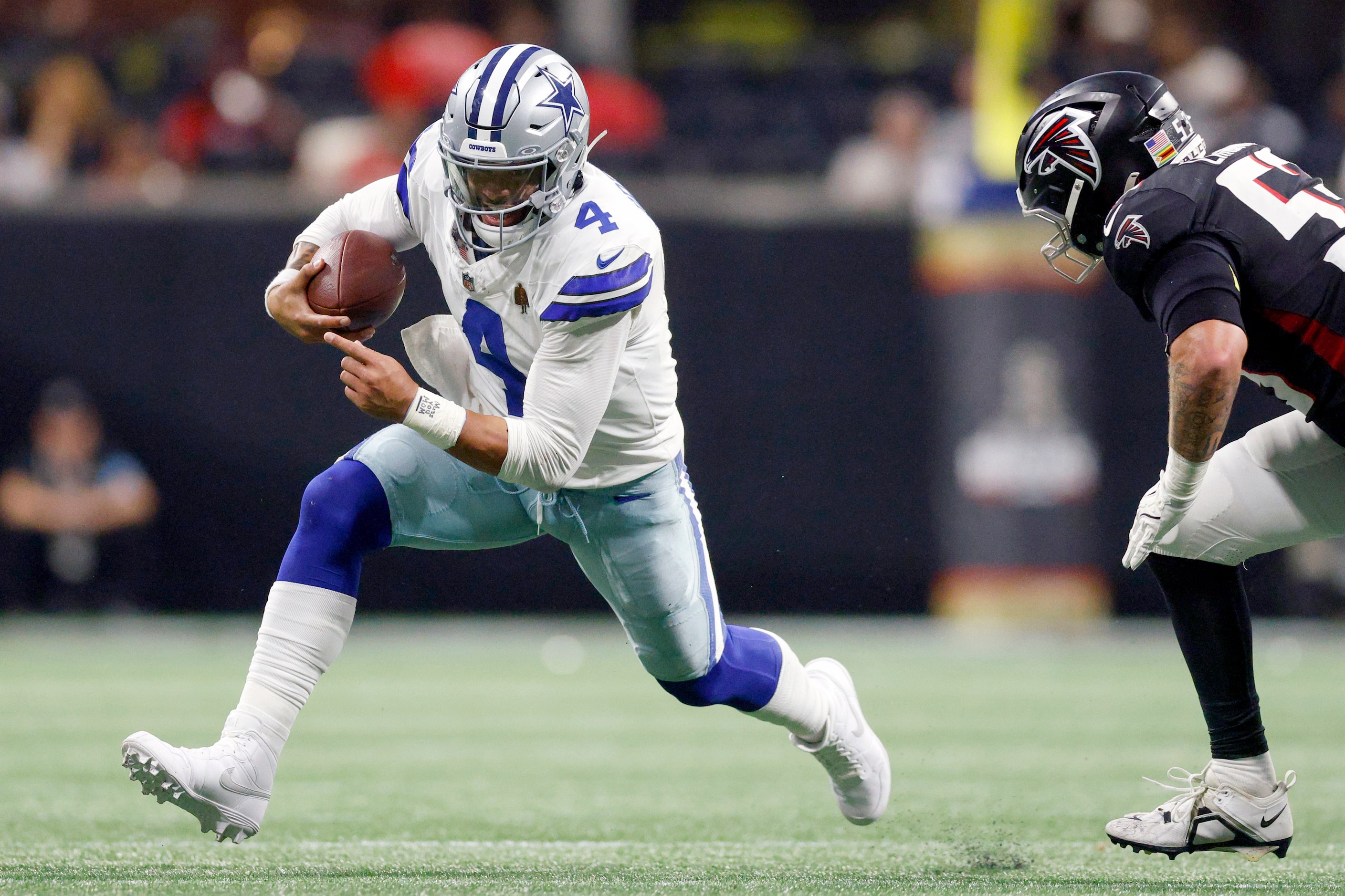 Dallas Cowboys quarterback Dak Prescott (4) runs the ball away from Atlanta Falcons...