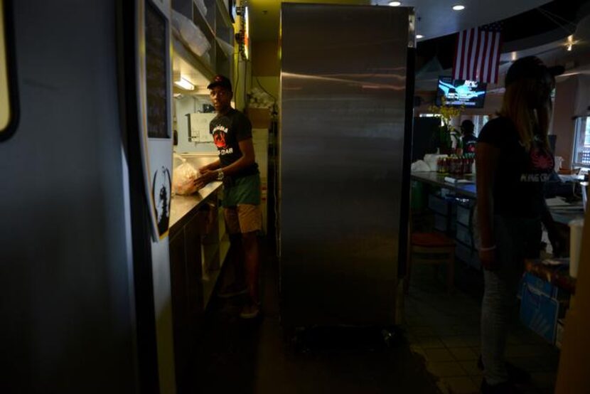 
Darian Hunter grabs an order from the kitchen at Louisiana King Crab. 
