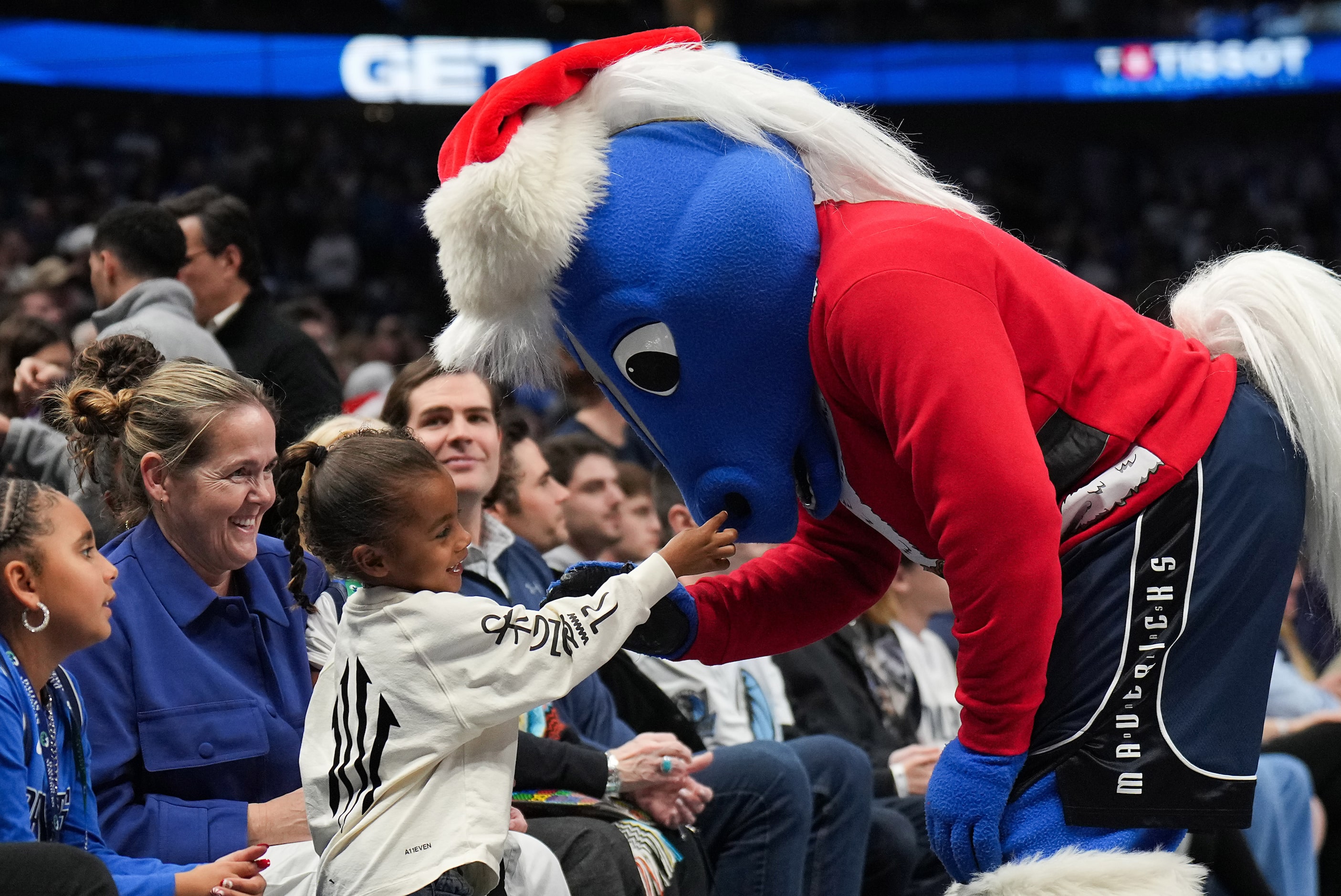 Dallas Mavericks mascot Champ wears a Christmas-themed costume while interacting with fans...