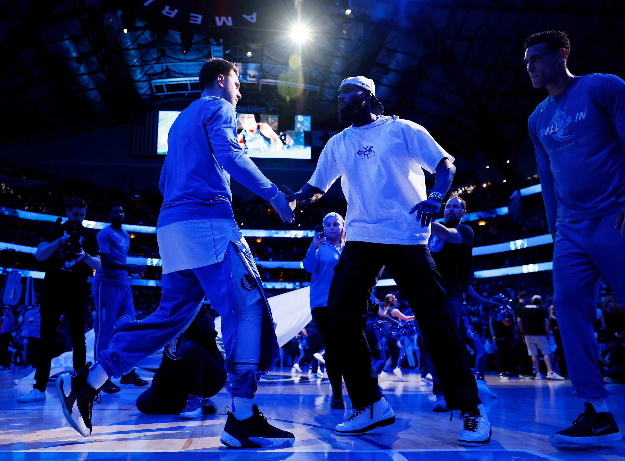 Dallas Mavericks guard Luka Doncic (77) is greeted by teammate Tim Hardaway Jr. (center)...