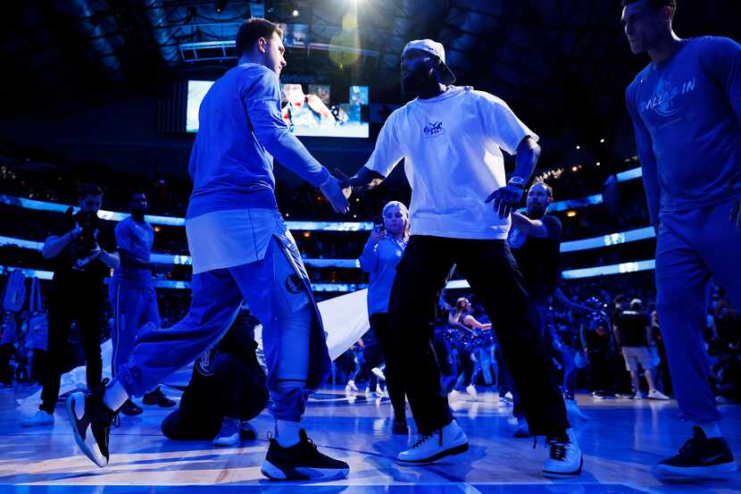 Dallas Mavericks guard Luka Doncic (77) is greeted by teammate Tim Hardaway Jr. (center)...