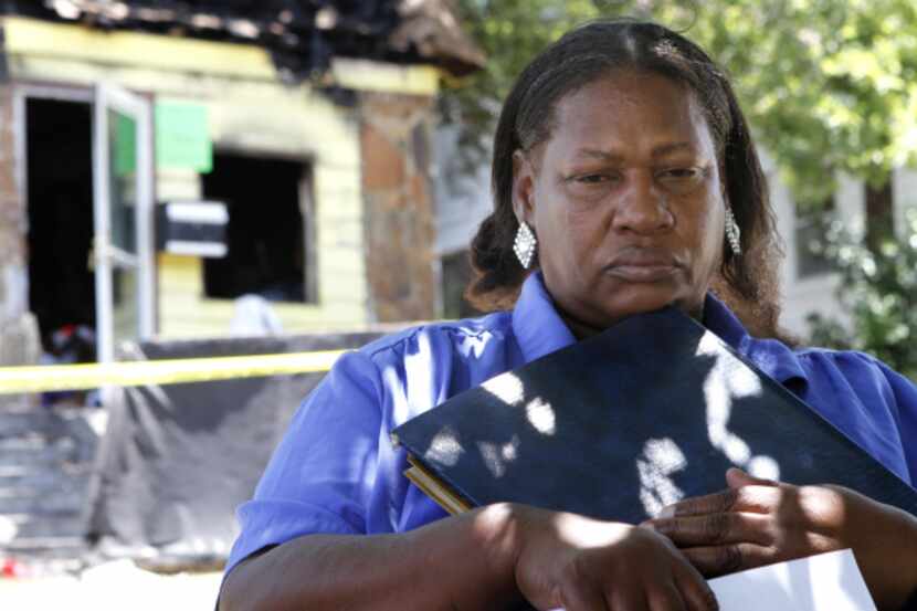 Dora Fuller clutches a photo album that was salvaged after a fire destroyed her house in...